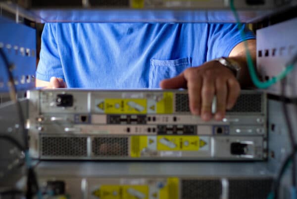 A TAMS team member pulling a server from a rack during a large scale data center decommissioning project