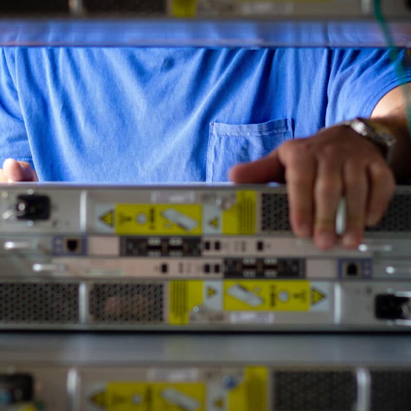 A TAMS team member pulling a server from a rack during a large scale data center decommissioning project