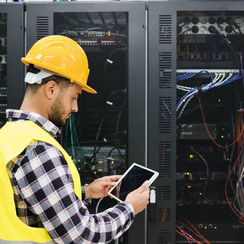 Data center technician with a tablet inspecting server racks during a decommissioning project