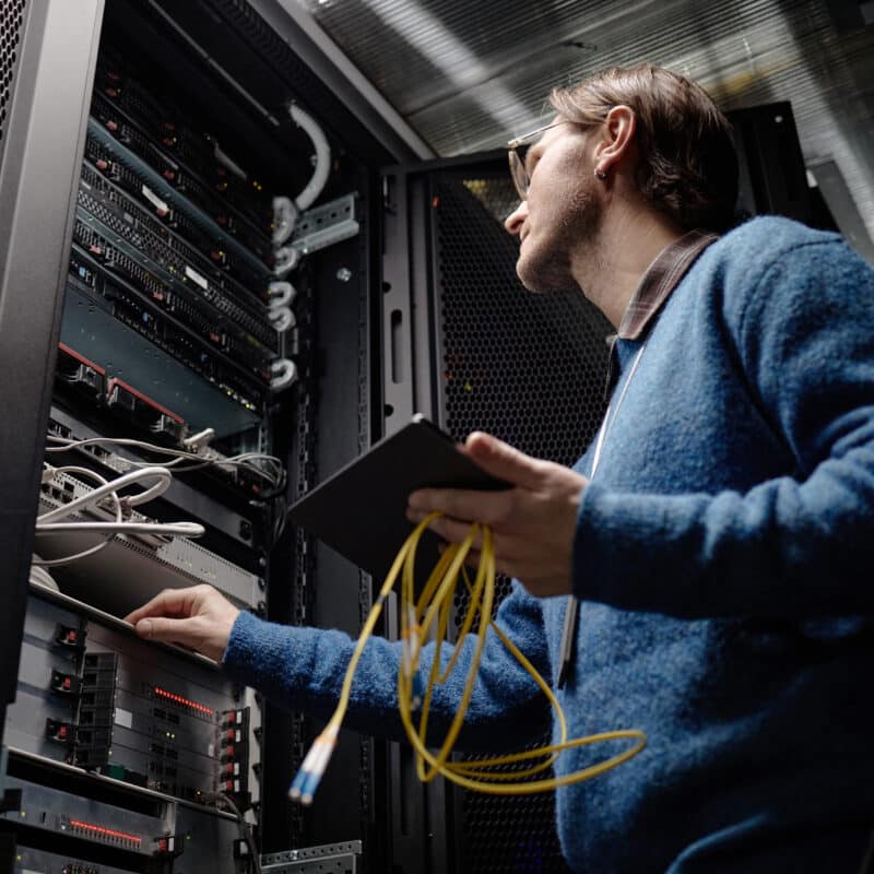 IT technician working on server racks during a financial institution IT refresh