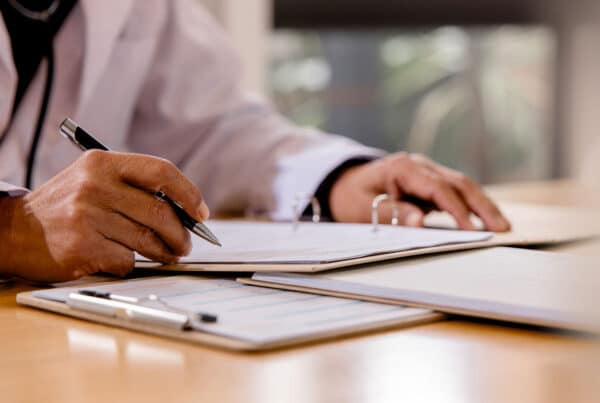 Healthcare professional reviewing paperwork while evaluating a hospital ITAD vendor.