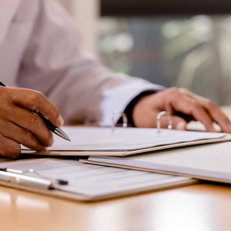 Healthcare professional reviewing paperwork while evaluating a hospital ITAD vendor.